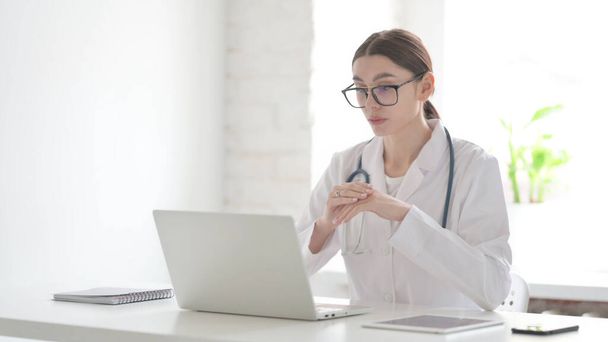 Mladá žena lékař mluvit na video hovor na notebooku v kanceláři - Fotografie, Obrázek