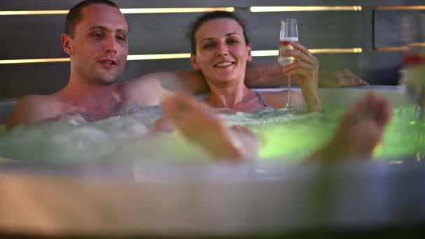 Couple caucasien ayant du temps romantique dans leur spa de bain à remous de jardin pendant les heures de nuit - Séquence, vidéo