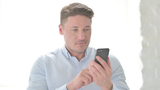 Portrait of Middle Aged Man using Smartphone - Фото, зображення
