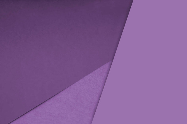 Tmavé a lehké, hladké a texturované odstíny fialových papírových linií na pozadí protínajících se do tvaru trojúhelníku - Fotografie, Obrázek