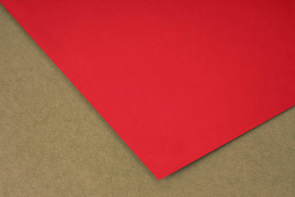 Tavallinen punainen paperi arkki makaa ruskea keltainen kuvioitu tausta kuin avoin kirja ylhäältä kulmasta - Valokuva, kuva