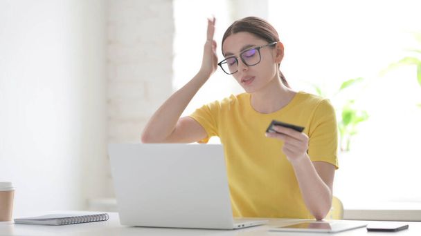 Mujer joven que hace el fracaso del pago en línea en el ordenador portátil en la oficina - Foto, imagen