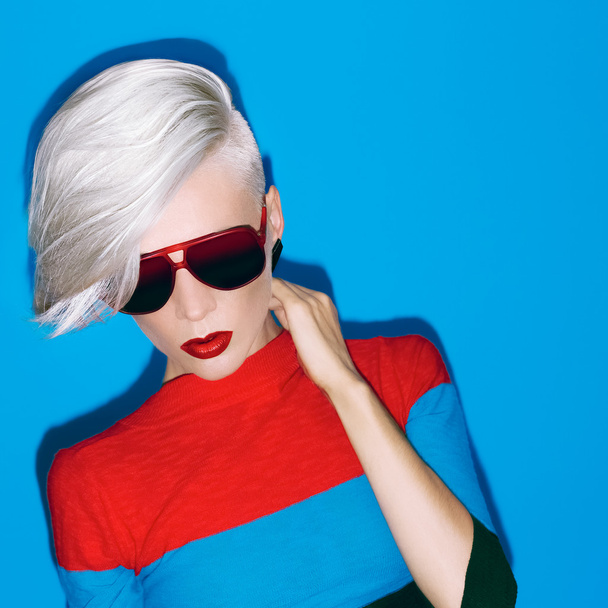 fashion blond lady with trendy hairstyle and sunglasses on a blu - Foto, imagen