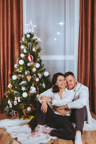 pareja disparando delante de decorado árbol de navidad copia espacio tarjeta de regalo - Foto, Imagen