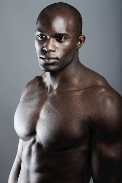 Dark and Brooding. Studio shot of a bare-chested african american man - 写真・画像