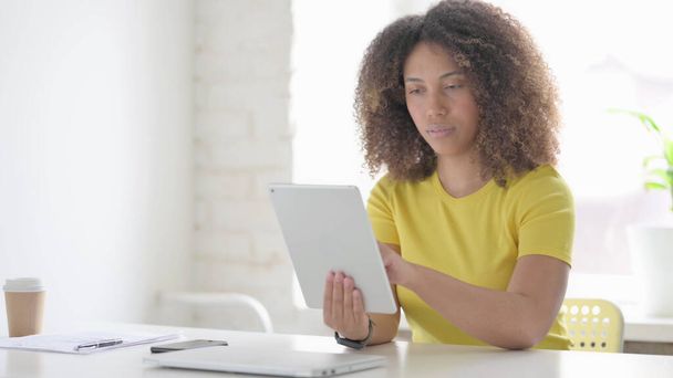 Joven mujer africana usando Tablet mientras está sentada en la oficina - Foto, imagen
