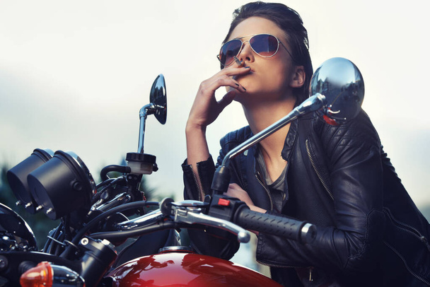Shes got the attitude of a biker. A hardcore and gorgeous young biker sitting on her motorbike - Foto, imagen