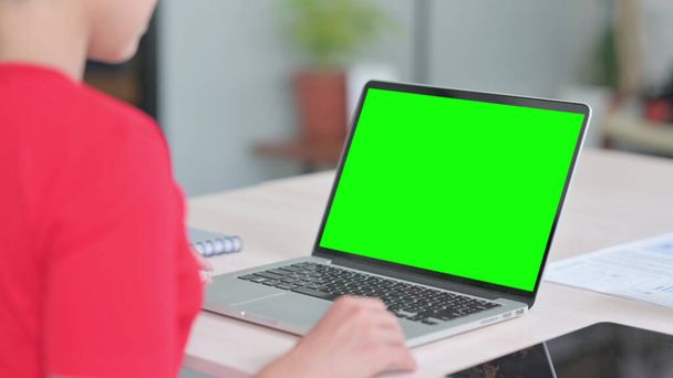 Mujer india joven usando el ordenador portátil con la pantalla dominante verde del croma - Foto, Imagen
