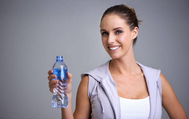A hidratação é importante. Retrato de uma jovem atraente segurando uma garrafa de água - Foto, Imagem