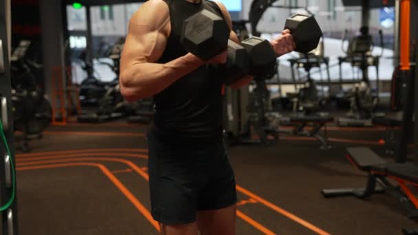 Athlete guy crop view doing dumbbell bicep tricep curls workout in gym, bodybuilding. Handsome power athletic man in training biceps - Footage, Video