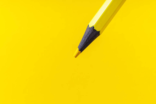 Цветной карандаш крупным планом с выборочным фокусом на стилусе и размытым желтым фоном. Копирование текста. - Фото, изображение