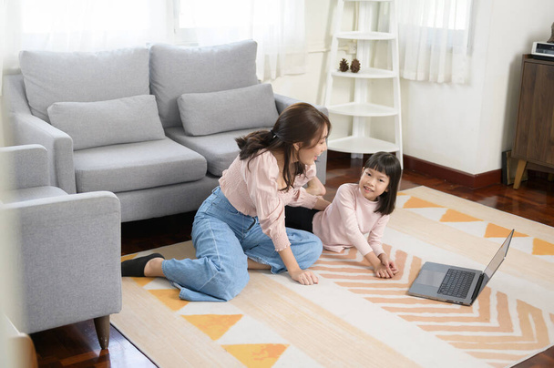 Азиатская семья с детьми с помощью ноутбука на дому  - Фото, изображение