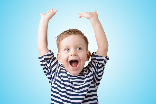 little boy with his hands up smiling - 写真・画像