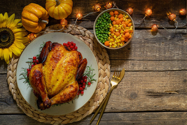 Pieczony cały kurczak lub indyk z warzywami na obiad dziękczynny na drewnianym stole. Koncepcja Święta Dziękczynienia. Widok z góry, przestrzeń kopiowania - Zdjęcie, obraz
