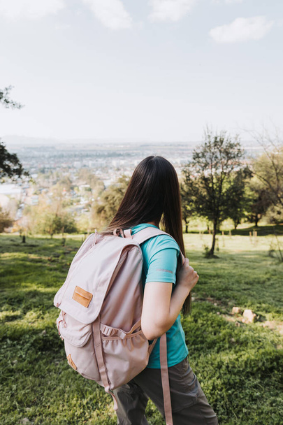 Jeune étudiante méconnaissable utilisant sac à dos rose regardant l'horizon de la colline. Confiance en soi. Photo de haute qualité - Photo, image