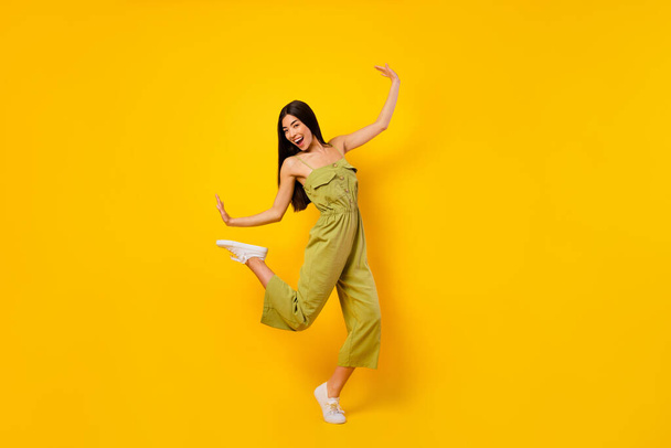Full length photo of carefree positive girl enjoy dancing clubbing rejoice isolated on yellow color background. - Foto, imagen