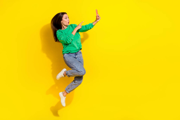 Full length portrait of impressed person jump point finger telephone isolated on yellow color background. - Foto, Imagem