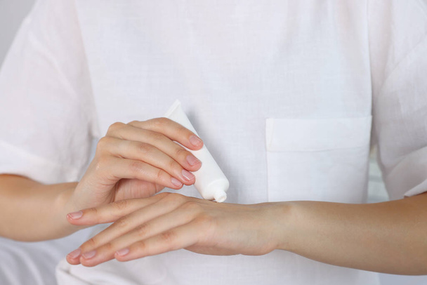 Woman applying cream on her hand indoors, closeup - Foto, Imagem