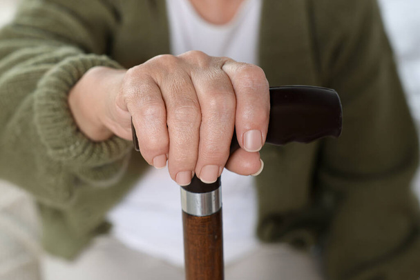 Elderly woman with walking cane indoors, closeup. Home care service - Fotoğraf, Görsel