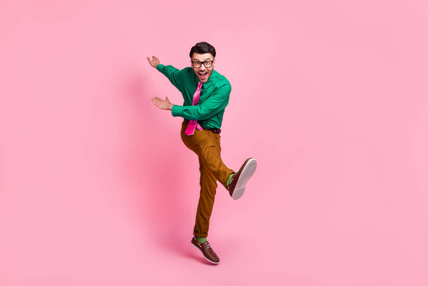 Full length photo of pretty positive man dressed green shirt eyewear dancing jumping isolated pink color background. - Fotografie, Obrázek
