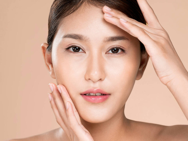 Closeup ardent young woman with healthy clear skin and soft makeup looking at camera and posing beauty gesture. Cosmetology skincare and beauty concept. - Foto, Imagem