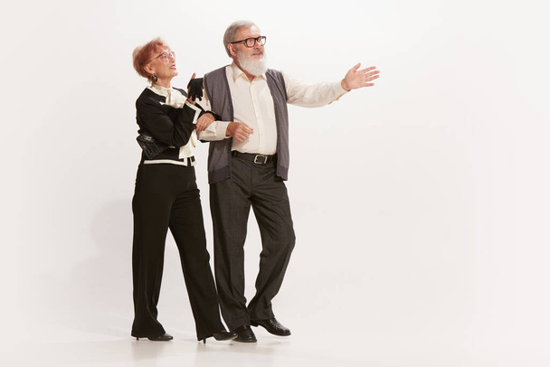 Выходные мероприятия. Красивый пожилой мужчина и очаровательная женщина среднего возраста в винтажном стиле осенние наряды изолированы на белом фоне. Отношения, семья, стиль ретро-моды 60-х - Фото, изображение