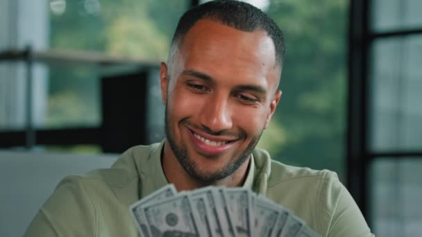 Happy smiling 30s rich man with bristle African American guy businessman investor winner glad about fan of money. Latino worker winning lottery holding dollars enjoy financial prize salary reward - Footage, Video