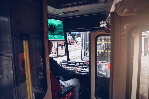 Трамвайный водитель управляет трамваем. Общественный транспорт - Фото, изображение
