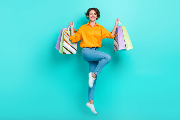 Full length photo of charming satisfied lady hold bags rejoice new collection stylish clothes outfit isolated on cyan color background. - Zdjęcie, obraz