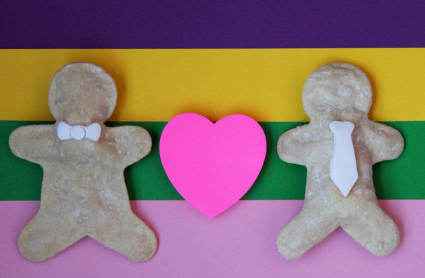 Imagen que representa el amor homosexual entre dos hombres hechos de jengibre con un corazón y la bandera del arco iris lgtb + - Foto, Imagen