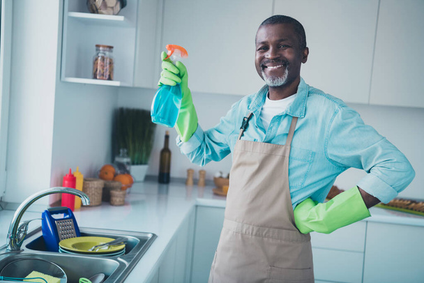 Portrait of cheerful positive person hold bottle cleaning detergent hand waist toothy smile house indoors. - Photo, Image