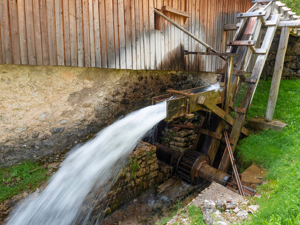 El poder del agua hace girar el viejo molino de agua de un aserradero. La ubicación es el Molveno, Dolomiti del Brenta Italia. Vacaciones de verano. - Foto, imagen