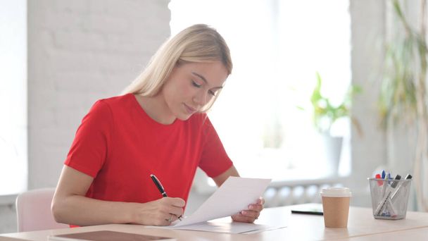 Young Woman Reading Documents, Doing Paperwork in Office - Foto, imagen