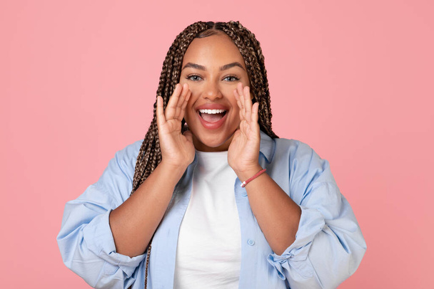 Excited African American Oversized Woman Shouting Holding Hands Near Face Announcing Wow Offer Looking At Camera Standing Over Pink Background In Studio. Hey You Concept - Photo, Image