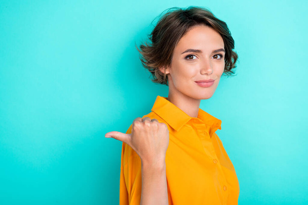 Photo of gorgeous nice cute woman with bob hairdo wear yellow blouse indicating empty space isolated on turquoise color background. - 写真・画像