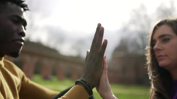 Διαφυλετικό ζευγάρι που κρατιέται χέρι-χέρι, ένωση ποικιλομορφίας - Πλάνα, βίντεο
