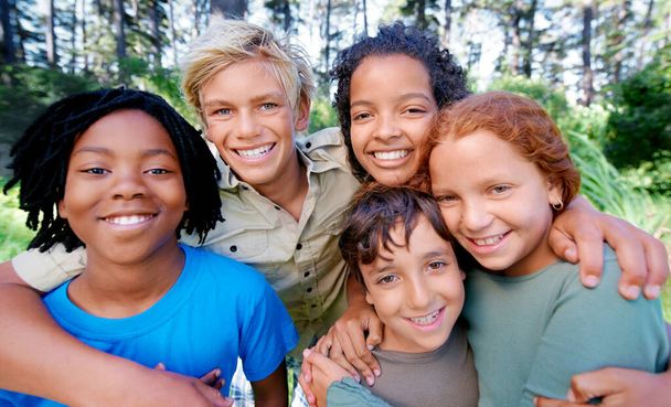 Spaß, Freunde und frische Luft. Nahaufnahme einer Gruppe von Kindern, die im Wald in die Kamera lächeln - Foto, Bild