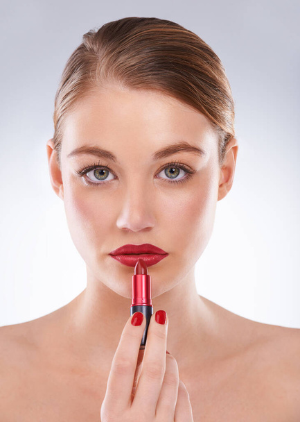 Red is the color of desire. Portrait of an attractive young woman wearing bright red lipstick and nail polish - Photo, image