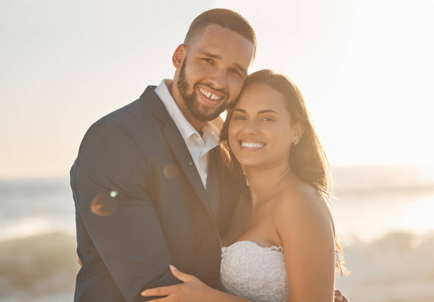 Love, couple and wedding portrait of bride and groom hug and bonding at beach, happy and cheerful. Freedom, romance and just married couple excited for ocean trip and honeymoon, celebrating marriage. - Fotografie, Obrázek
