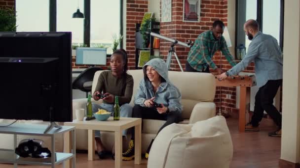Zróżnicowany zespół kobiet grających w gry wideo na konsoli telewizyjnej, bawiących się grą w domu. Wesołych ludzi korzystających z konkurencji gier online i wyzwanie w znajomych hangout. - Materiał filmowy, wideo