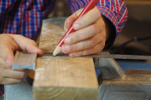 Carpenter in the workshop prepares a cutting raw board. Joiner worker in carpentry shop. A thorough expert and careful craftsman focused on work. - Photo, Image