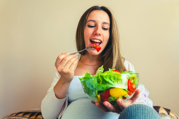 Вагітний салат здорова їжа. Вагітність жінка їсть дієтичний харчовий салат. Сімейне харчування, концепція здорового харчування
 - Фото, зображення