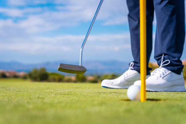 Hitting the green with the putter. The ball in the hole. man playing golf - Foto, Imagen