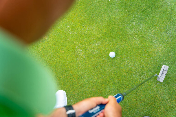 Man playing golf, detail of a shot with the putter on the green, view from above - Fotoğraf, Görsel