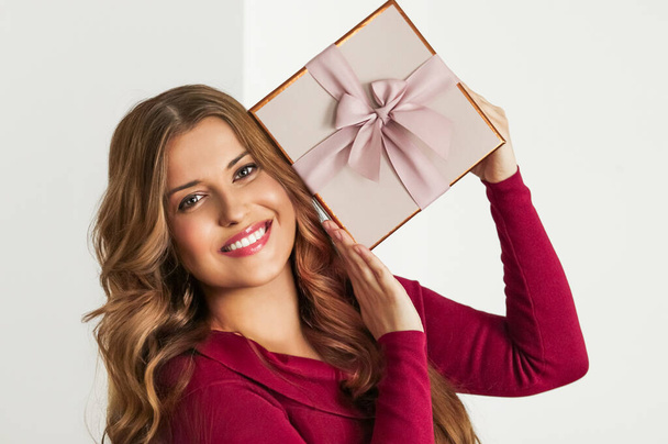 Holiday present for birthday, baby shower, wedding or luxury beauty box subscription delivery, happy woman holding a wrapped pink gift on white background - Photo, Image