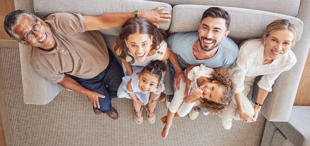 Children, parents and grandparents on sofa with above view and generations of family spending time together. Love, diversity and couple with girl kids, grandma and grandpa relax and smile at home - Photo, image