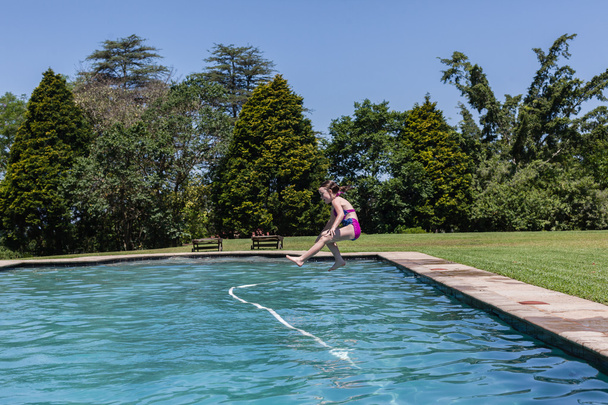 Tyttö hyppää uima-allas
 - Valokuva, kuva