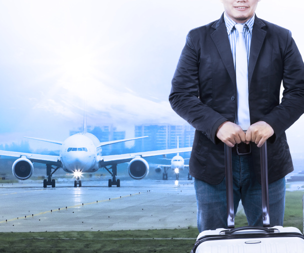 Νεαρός άνδρας και ταξιδεύουν τὰ staning αποσκευές μπροστά από το αεροπλάνο - Φωτογραφία, εικόνα