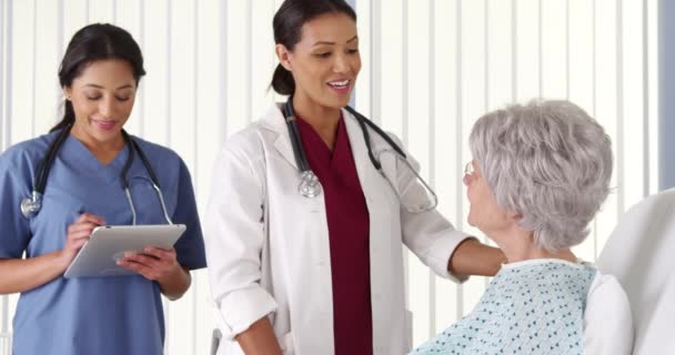 Médico afroamericano hablando con anciana paciente con enfermera
 - Imágenes, Vídeo