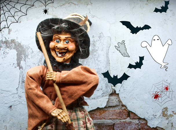 Halloween Witch doll in decorated dress holding a wooden broom. Trick or treat. Happy Halloween. - Photo, Image